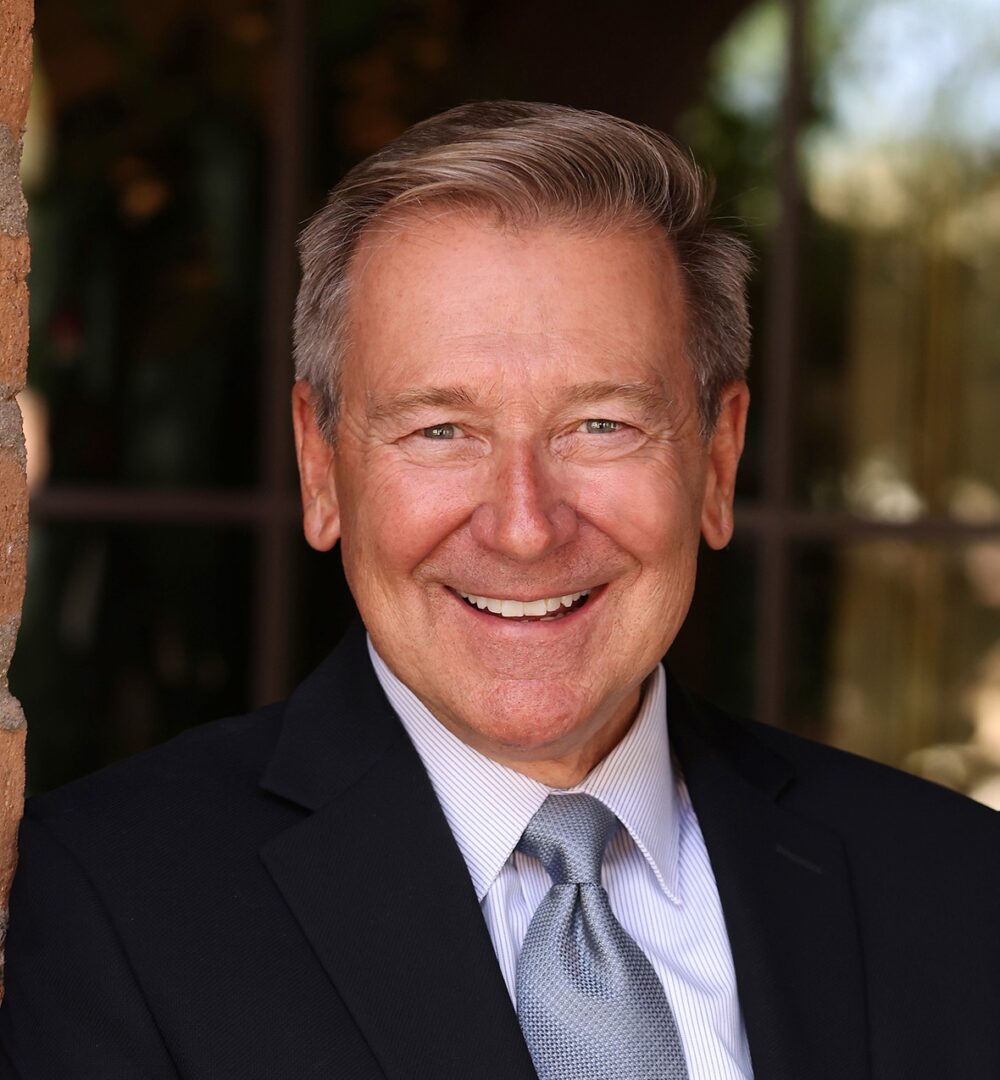 Chuck Disney in a Black Suit Smiling Headshot